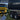 Two trucks, one yellow and one black, with a close-up of a blue hammock in the foreground.