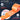 Orange industrial polyester webbing with text highlighting resistance properties on a dark background